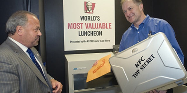 Corporate security expert Bo Dietl (l.) watches as Roger Eaton, president of KFC USA, places Colonel Harland Sanders' handwritten Original Recipe into KFC headquarters' newly modernized vault in April, 2009.