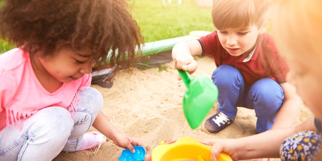 These kids are completely absorbed in their sandbox fun at a local park.