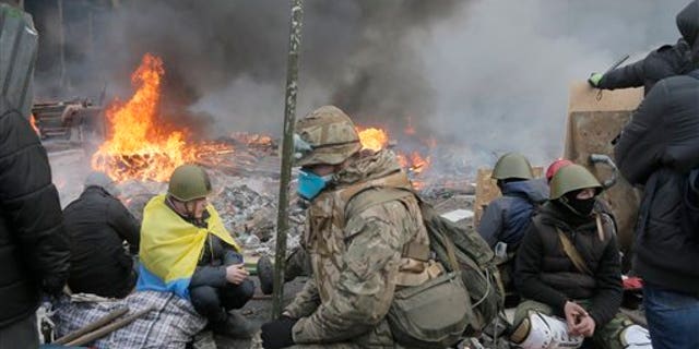 Anti-government protesters relax at the barricades during clashes with riot police in Kiev's Independence Square, the epicenter of the country's current unrest, Kiev, Ukraine, Wednesday, Feb. 19, 2014.  The deadly clashes in Ukraines capital have drawn sharp reactions from Washington, generated talk of possible European Union sanctions and led to a Kremlin statement blaming Europe and the West. A roundup of some of the international reactions. (AP Photo/Efrem Lukatsky)
