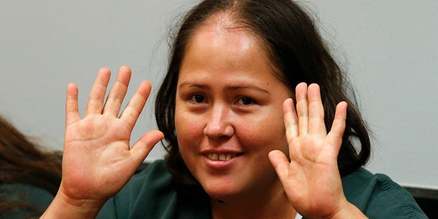 Isabel Martinez gestures towards news cameras during her first court appearance Friday, July 7, 2017, in Lawrenceville, Ga. Martinez is charged with killing four of her children and their father. (AP Photo/John Bazemore)