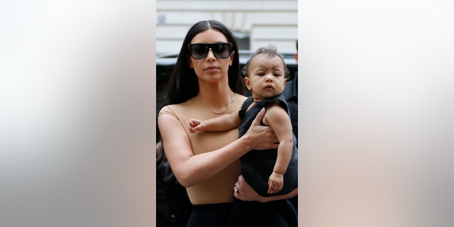 May 20, 2014. TV personality Kim Kardashian holds her daughter North, in her arms as she shops in Paris.