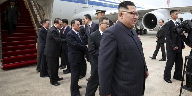 In this photo released by the Ministry of Communications and Information of Singapore, North Korean leader Kim Jong Un, right, arrives at the Changi International Airport.