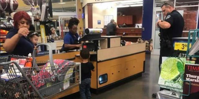 Kennesaw police officer Matt Wilson, right, helps a local mom.