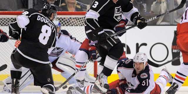 Feb. 1, 2012: Los Angeles Kings defenseman Drew Doughty, left, shoots and scores to win the game on Columbus Blue Jackets goalie Curtis Sanford, second from left, as Los Angeles Kings defenseman Jack Johnson, second from right, jumps out of the way and Columbus Blue Jackets defenseman Fedor Tyutin of Russia falls during the third period of their NHL hockey game in Los Angeles. The Kings won 3-2.