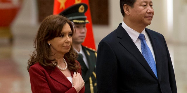 Argentine President Cristina Fernandez places her hand over her chest as she stands next to Chinese President Xi Jinping while the Argentine national anthem is played during a welcome ceremony at the Great Hall of the People in Beijing Wednesday, Feb. 4, 2015. (AP Photo/Ng Han Guan)