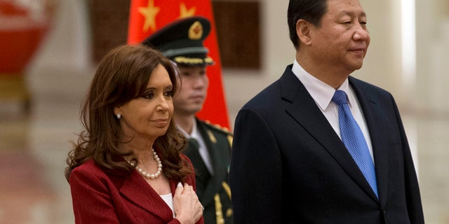Argentine President Cristina Fernandez places her hand over her chest as she stands next to Chinese President Xi Jinping while the Argentine national anthem is played during a welcome ceremony at the Great Hall of the People in Beijing Wednesday, Feb. 4, 2015. (AP Photo/Ng Han Guan)