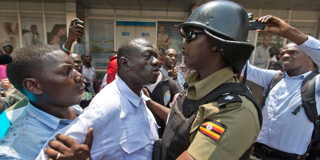 Feb. 15, 2016: Leading opposition leader and presidential candidate Kizza Besigye, center, is grabbed before being arrested by riot police in downtown Kampala, Uganda.