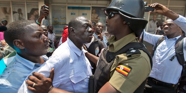Feb. 15, 2016: Leading opposition leader and presidential candidate Kizza Besigye, center, is grabbed before being arrested by riot police in downtown Kampala, Uganda.