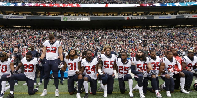 Houston Texans players kneel and stand during the singing of the national anthem before an NFL football game against the Seattle Seahawks, Sunday, Oct. 29, 2017, in Seattle.
