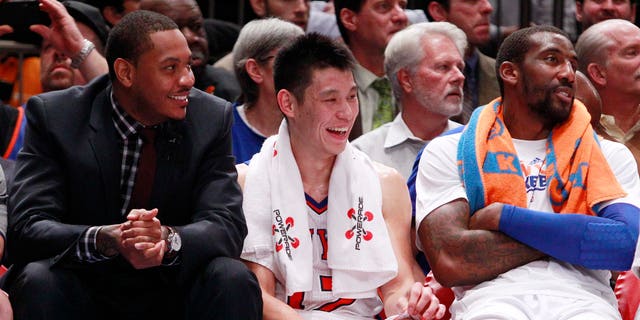 New York Knicks' Jeremy Lin, center, talks with teammates Carmelo Anthony, left, and Amare Stoudemire, right,  Wednesday, Feb. 15, 2012, in New York.  (AP Photo/Frank Franklin II)