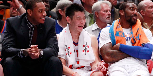 New York Knicks' Jeremy Lin, center, talks with teammates Carmelo Anthony, left, and Amare Stoudemire, right, Wednesday, Feb. 15, 2012, in New York. (AP Photo/Frank Franklin II)
