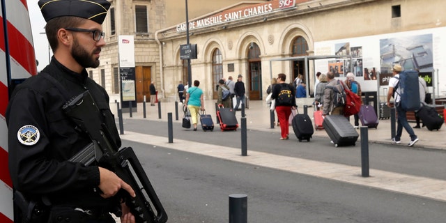 A police officer stands guard near the Marseille Saint Charles train station a day after a man fatally stabbed two women in Marseille, France, Monday, Oct. 2, 2017.