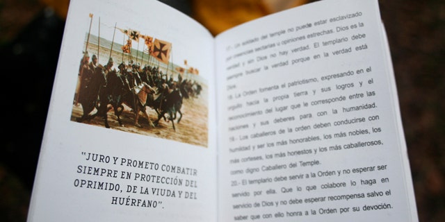 July 14: A soldier holds a code-of-conduct booklet, allegedly made by the Knights Templar drug cartel, that was seized when a training camp was discovered after a firefight between Mexican army soldiers and gunmen in the woods near the town of Santa Gertrudis, Mexico. The "Knights Templar of Michoacan," a new drug cartel that was created after it splintered from the La Familia cartel last March, has issued a code-of-conduct booklet for members saying it is fighting a war against tyranny and injustice.