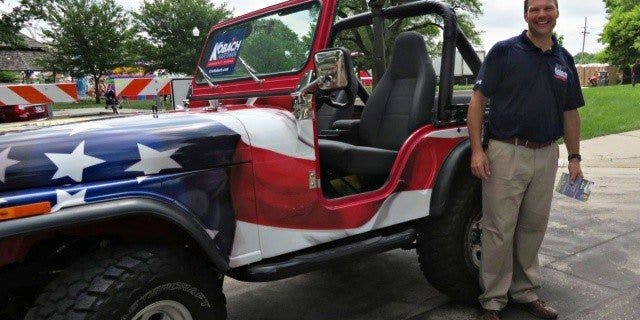 Republican Kansas governor hopeful Kris Kobach pictured with the jeep mounted with a replica of a gun that sparked the outrage.
