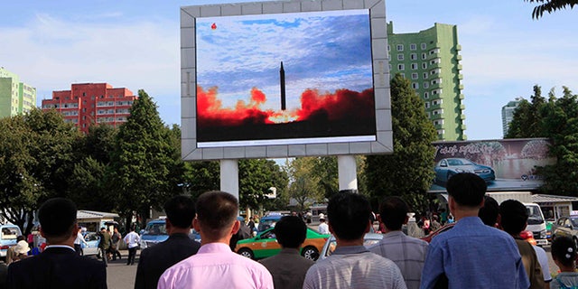 Photo released Saturday shows people watching a launching of a Hwasong-12 strategic ballistic rocket aired on a public TV screen at the Pyongyang Train Station in Pyongyang, North Korea.