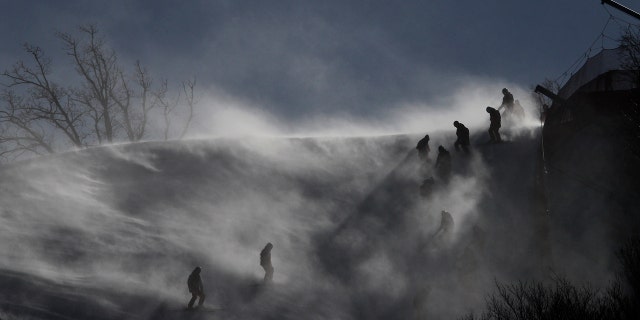 Course crew are shrouded in snow as they slip slide to the finish at the women's giant slalom.