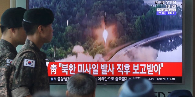 Army soldiers walk by a TV news program showing a file image of a missile being test-launched by North Korea at the Seoul Railway Station in Seoul, South Korea, Tuesday, July 4, 2017. North Korea on Tuesday launched yet another ballistic missile in the direction of Japan, South Korean officials said, part of a string of recent test-firings as the North works to build a nuclear-tipped missile that could reach the United States. The signs read "The presidential Blue House was briefed immediately after the North Korean missile was fired." (AP Photo/Ahn Young-joon)