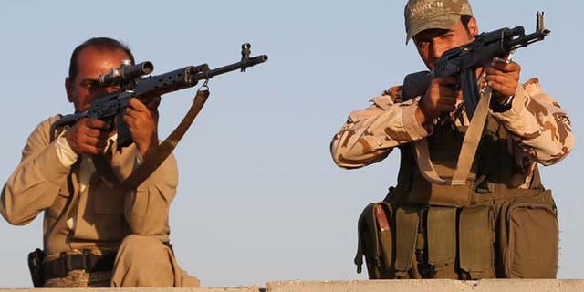 FILE: Aug. 8, 2014: Kurdish Peshmerga fighters during airstrikes targeting Islamic State militants outside of the city of Irbil in northern Iraq.