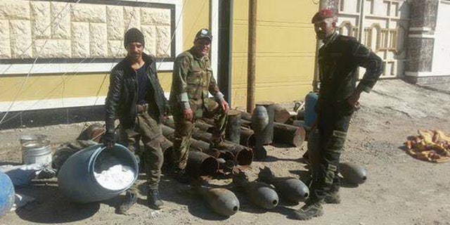 Kurdish fighters stand with seized - and unmaintained - ISIS armaments.