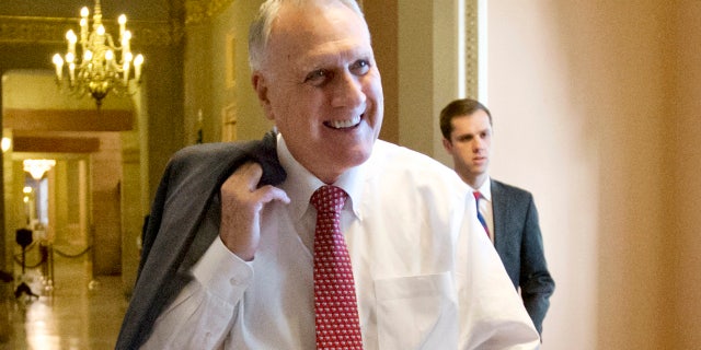 In this Dec. 30, 2012, file photo, Senate Minority Whip Jon Kyl, R-Ariz., walks between the Senate chamber and the office of Senate Minority Leader Mitch McConnell, R-Ky., in Washington.
