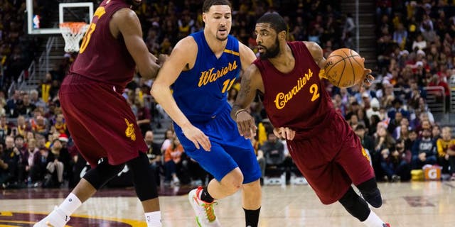 Tristan Thompson #13 sets a pick as Kyrie Irving #2 of the Cleveland Cavaliers drives around Klay Thompson #11 of the Golden State Warriors during the second half at Quicken Loans Arena on December 25, 2016 in Cleveland, Ohio.