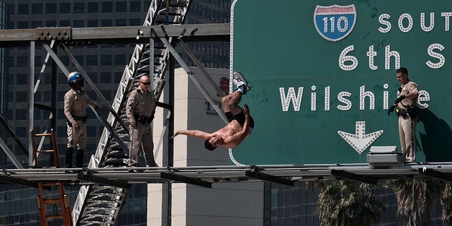 Alexander Dunn does a backflip off a sign over the 110 Freeway in Los Angeles onto a landing pad below on June 27, 2017.