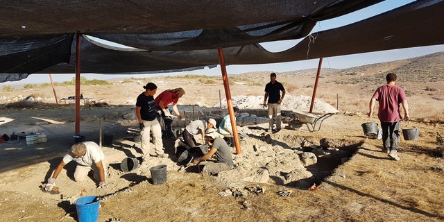 Archaeologists uncover the ancient structure.