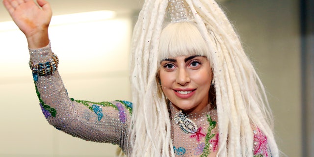August 12, 2014. Singer Lady Gaga waves upon her arrival at Narita international airport, east of Tokyo.