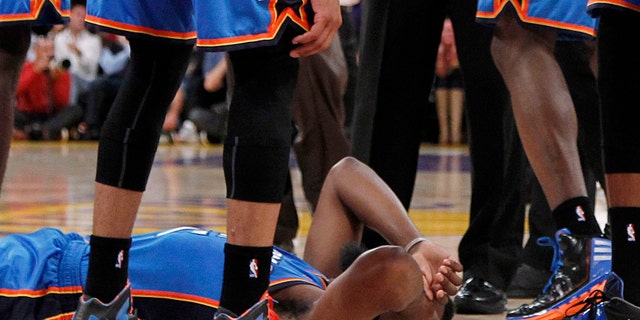 April 22: Oklahoma City Thunder players stand over teammate James Harden, lower left, after receiving a flagrant double foul from Los Angeles Lakers' Metta World Peace, who was then ejected, in the first half of an NBA basketball game in Los Angeles.