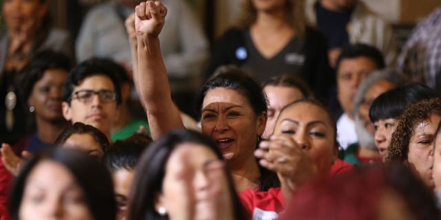 May 19, 2015: Workers react as the Los Angeles City Council votes to raise the minimum wage in the city to $15 an hour by 2020, making it the largest city in the nation to do so, in Los Angeles. (AP)