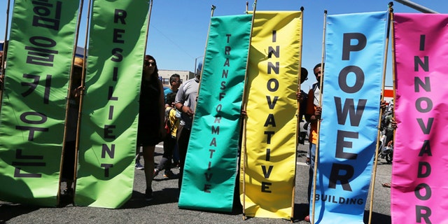 Inspirational messages in multiple languages are seen on banners at the corner of Florence and Normandie, the flash point of riots that erupted after the 1992 acquittal of four white police officers in the beating of black motorist Rodney King, on the 25th anniversary, in Los Angeles, Saturday, April 29, 2017.