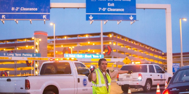 Officials redirect traffic after a shooting in a parking garage at McCarran International Airport on Monday, Sept. 19, 2016, in Las Vegas.