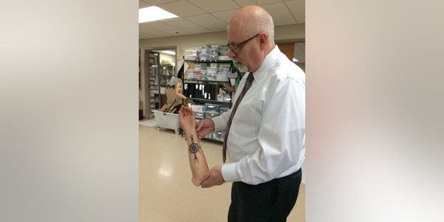 Dave Laufer, director of orthotics and prosthetics at Walter Reed National Military Center, displays a customized limb featuring a tattoo.