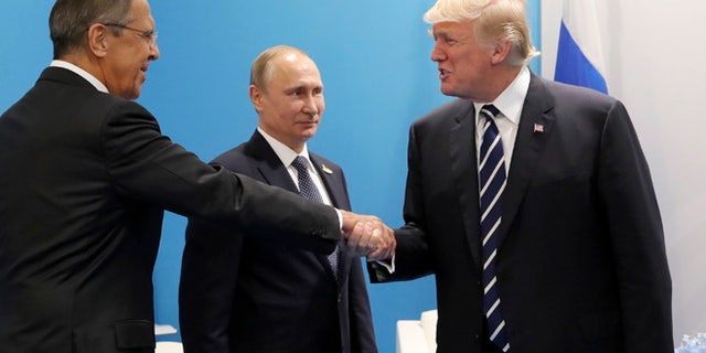 U.S. President Donald Trump, right, greets Russian Foreign Minister Sergey Lavrov, left, prior his talks with Russian President Vladimir Putin, center, during the G20 summit in Hamburg Germany, Friday July 7, 2017. (Mikhail Klimentyev, Kremlin Pool Photo via AP)