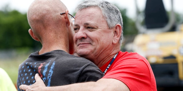 Tony Heineman, advancement and development officer for Soldier's Wish, hugs Cody Nichols, left, after presenting him with new lawn equipment at Bloss Equipment in Tulsa, Okla., on Friday, June 22, 2018.