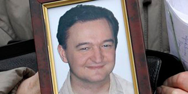 FILE - This is a Monday, Nov. 30, 2009 file photo showing a portrait of lawyer Sergei Magnitsky who died in jail, as it is held by his mother Nataliya Magnitskaya, as she speaks during an exclusive interview with the AP in Moscow, Russia, Monday, Nov. 30, 2009. Activists plan to present evidence Tuesday, July 5, 2011, that a Russian lawyer who accused officials of corruption died after a brutal beating by prison guards, saying investigators' findings that a lack of medical treatment killed the man fell short of the full truth. (AP Photo/Alexander Zemlianichenko, File)