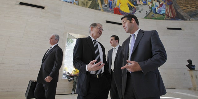 Plaintiff's attorneys Lewis Eidson, second from left, and Curtis Miner, far right, with the Law Firm of Colson Hicks Eidson, stand in line before a security check to attend a hearing on the Toyota Motor Corp.