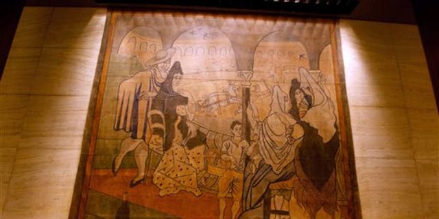 FILE- In this Feb. 28, 2014, file photo provided by the New York Landmarks Conservancy, a stage curtain painted by Pablo Picasso hangs on a wall at the Four Seasons restaurant in New York. The 19-by-20-foot curtain, called "Le Tricorne," is being donated to the New-York Historical Society, painting owner the Landmarks Conservancy said on Thursday, June 12, 2014. The curtain was at the center of a legal dispute between the restaurants landlord, who wanted it moved so the wall behind it can be repaired. (AP Photo/New York Landmarks Conservancy, Rick Bruner, File)