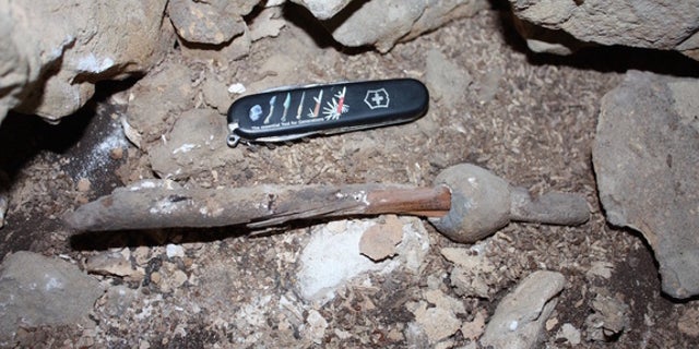 The ancient lead and wood artifact isn't much larger than a modern pocketknife.