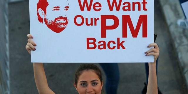 A woman holds a sign in Beirut, Lebanon, Nov. 12, 2017.