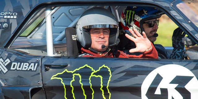 Actor and Top Gear presenter Matt LeBlanc, left, waves , as he sits with rally driver Ken Block during filming of BBC Top Gear in Westminster, London on Sunday Sunday March 13, 2016 .