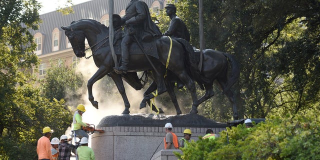 Workers remove a statue of Robert E. Lee in Dallas on September 14, 2017.