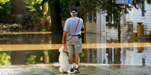 Sept. 10: John Wimer, and his dog Carlie, look at his neighborhood in the Shipoke area after flooding caused by the remnants of Tropical Storm Lee in Harrisburg, Pa.