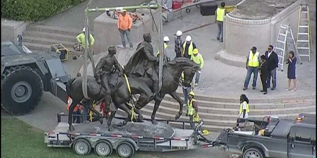 A statue of Robert E. Lee is removed from its pedestal in the Oak Lawn section of Dallas Thursday night.