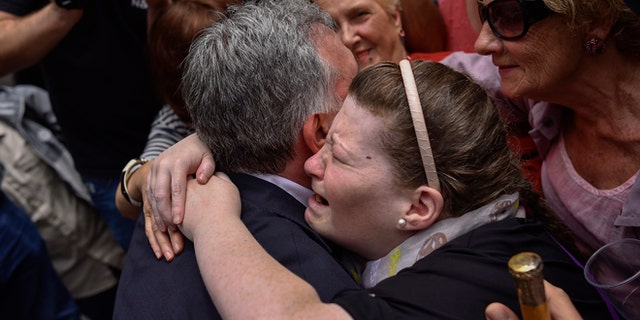 June 13, 2015: A woman cries as she embraces Pamplona's new Mayor and member of the Basque independence party EH Bildu, Joseba Asiron, left, in Ayuntamiento Square, in Pamplona, northern Spain. (AP)