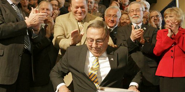 Maine Gov. Paul LePage smiles as he is congratulated after signing the health insurance overhaul bill at a State House signing ceremony in Augusta, Maine on May 17.