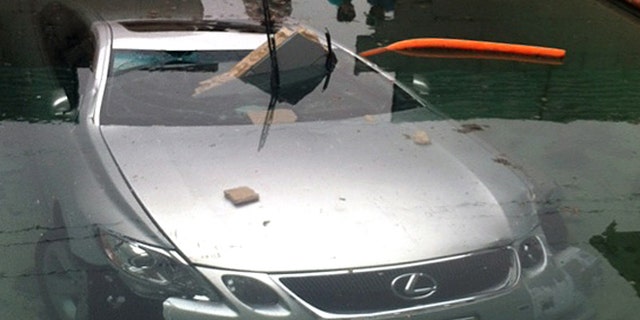 May 13, 2012: In this photo provided by Beatriz Diaz, officials investigate the scene where a man crashed his car through a wall and into a swimming pool in La Puente, Calif., early Sunday morning.