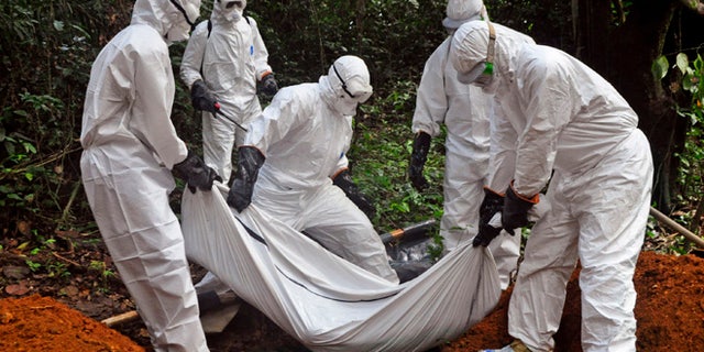 Oct. 20, 2014: Health workers bury the body of a woman who is suspected of having died of the Ebola virus in Bomi county, on the outskirts of Monrovia, Liberia.