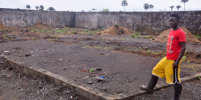In this photo taken Saturday, March 26, 2015, a boy, stands next to a place that was used to stack bodys of Ebola victims at a crematorium in Boys Town on the outskirts of Monrovia, Liberia.
