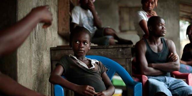 Sept. 28, 2014: Kumba "survivor" Fayiah, 11, sits with relatives in her St Paul Bridge home in Monrovia, Liberia. Fayah, who lost both parents and her sister, recovered from the Ebola virus and is now living with her extended family.